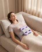 Woman resting on a sofa with the Unwind ring on her lower belly