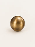 Bruno knob in aged brass, studio photo on a warm white background