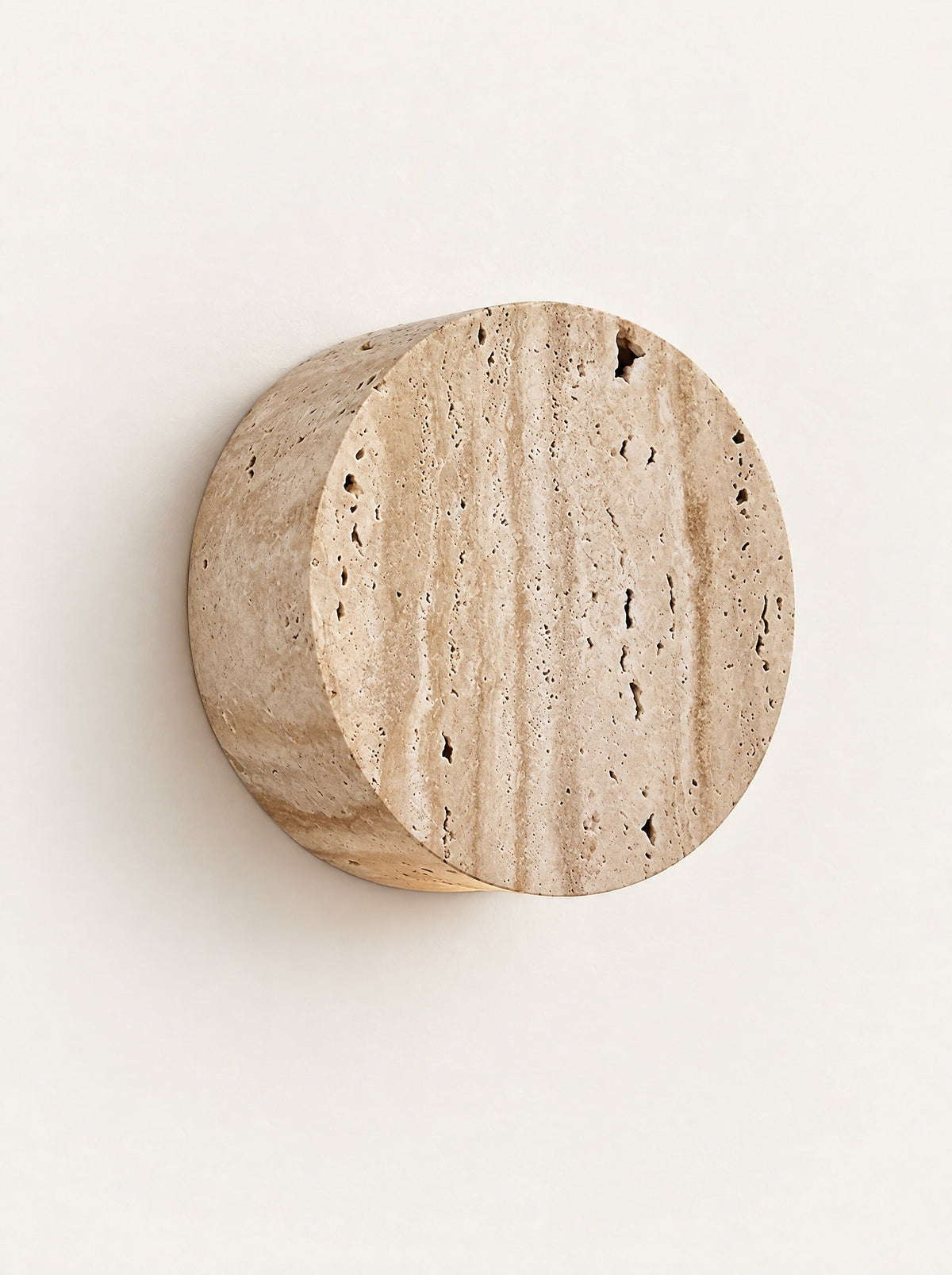 Coin Travertine Wall Light, studio photo on a warm white background