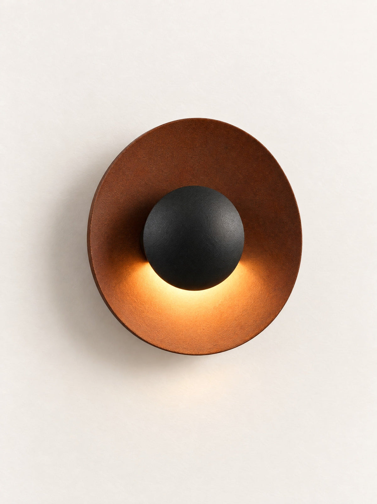 Corona Metal Disc Wall Light switched on, studio photo on a warm white background