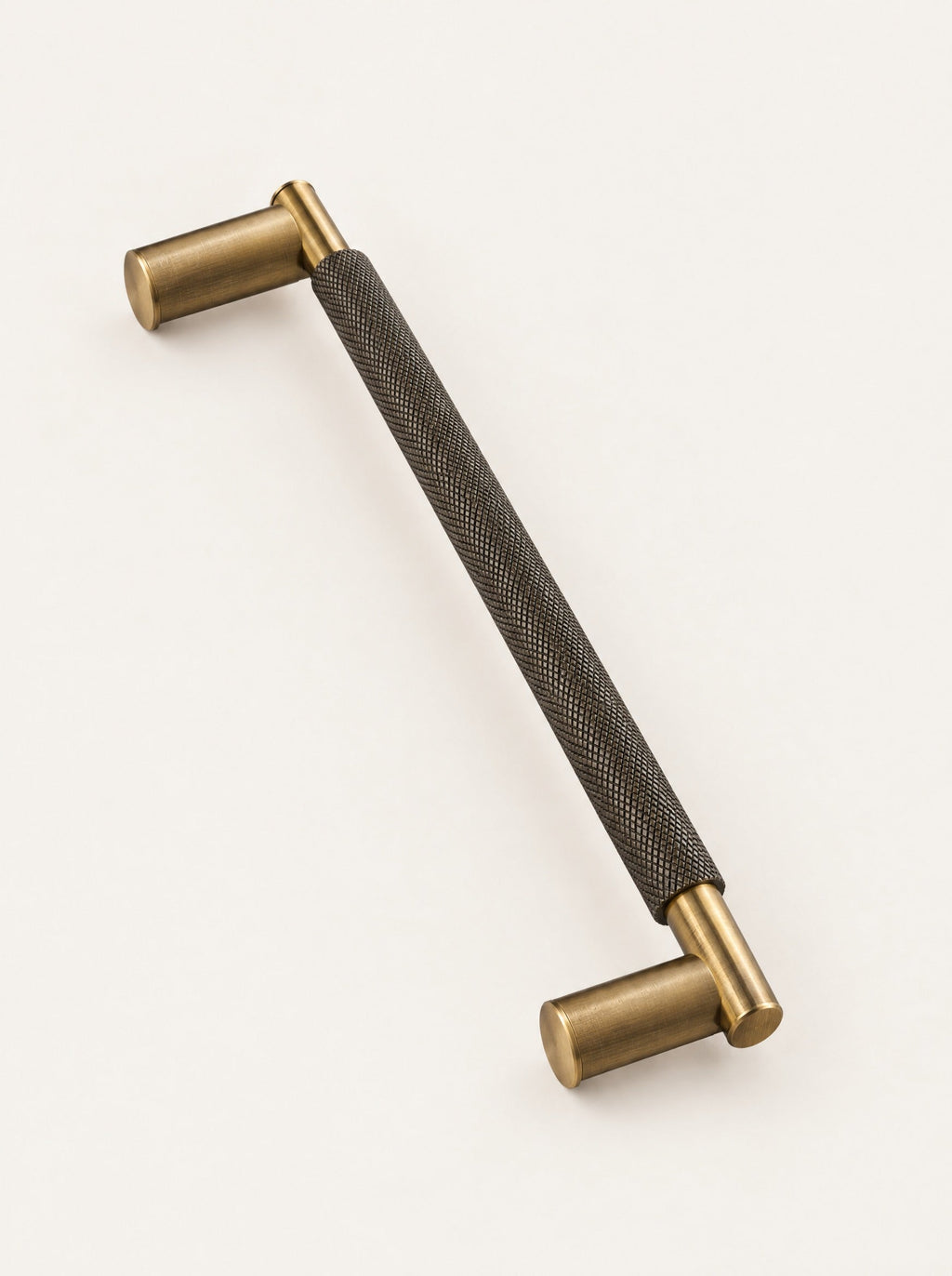 Knurl Brass Door Pull, close-up studio photo on a warm white background