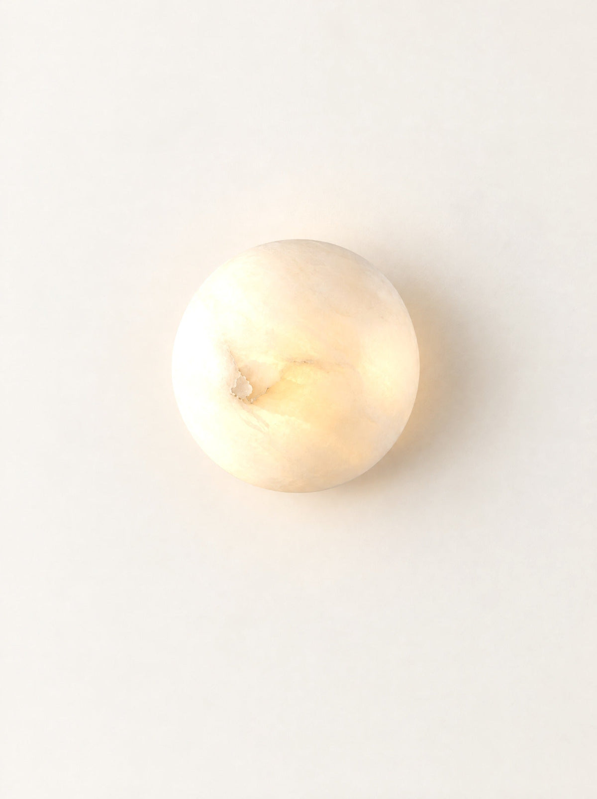 Luna Marble Wall Light switched on, studio photo on a warm white background