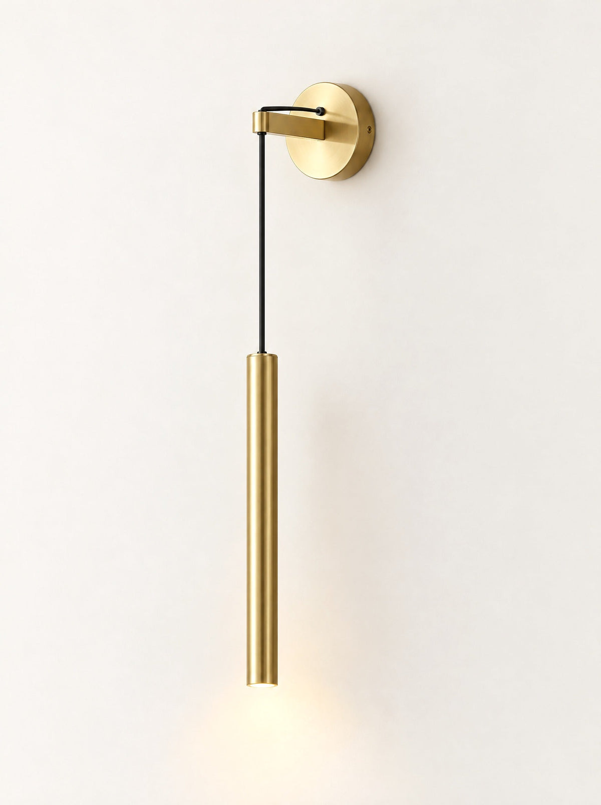 Plumb Brass Drop Wall Light switched on, studio photo on a warm white background