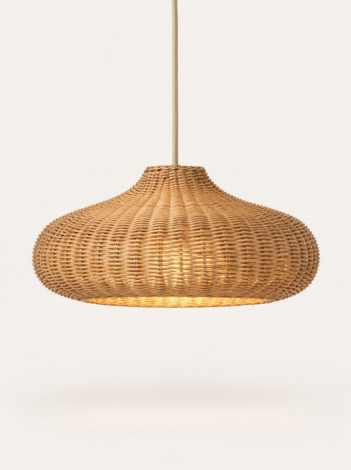 Weave Rattan Pendant switched on, studio photo on a warm white background